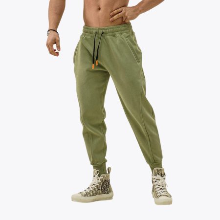 Model wearing green cotton gym jogger pants with black drawstrings and sneakers, showcasing a comfortable and sporty look.