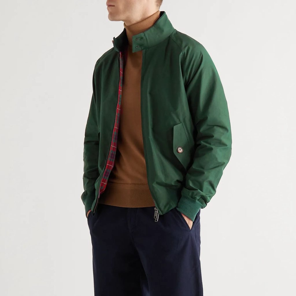 Man wearing a green bomber jacket with a classic design, featuring a zippered front and side pockets