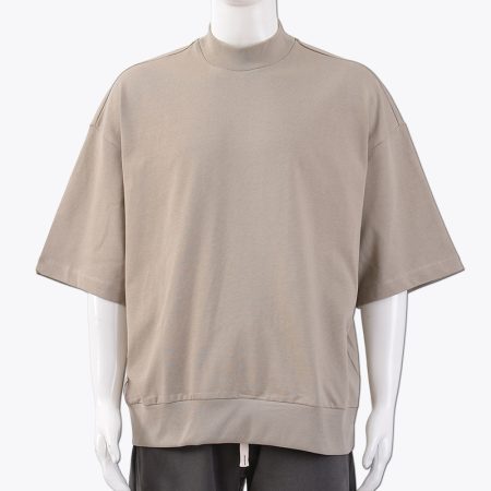 A beige oversized T-shirt worn by a mannequin, showcasing the relaxed fit and modern style.
