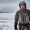 A person testing outdoor apparel in snowy, icy conditions during a real-world simulation of extreme weather