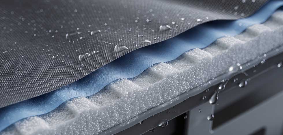 A close-up of a waterproof fabric showing water resistance as droplets bead on the surface.