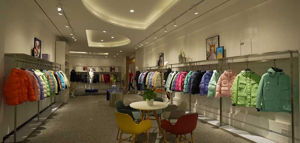 A showroom displaying colorful outdoor jackets on racks, showcasing a variety of styles and colors