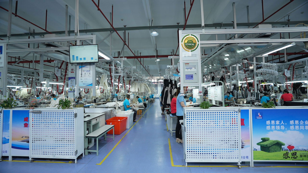 Factory floor showing workers assembling garments in an ethical apparel manufacturing setup.
