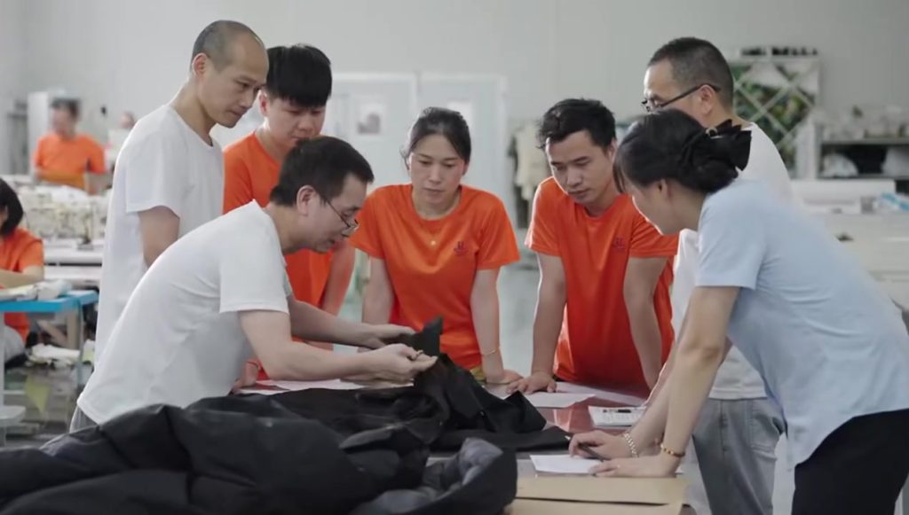 Group of workers and managers reviewing garment samples demonstrating fair labor practices.