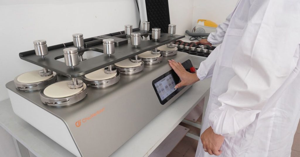Multi-head abrasion tester operated by lab technician
