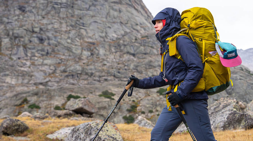 Hiker wearing technical outerwear and carrying a large backpack during a mountain trekking test
