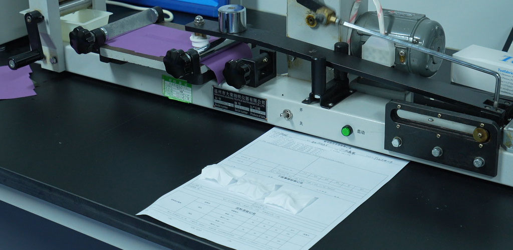 Abrasion resistance testing machine evaluating fabric durability for performance apparel