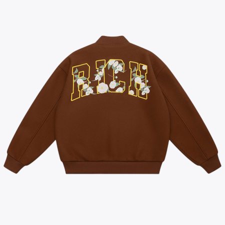 back view of the brown Simmerui baseball jacket featuring a classic snap button closure, ribbed collar and hem, with a bold yellow embroidered Happy Birthday graphic on the right chest and a large letter H logo on the left chest.