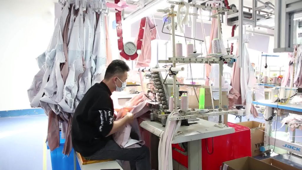 Sewing operators working on garments representing a professional apparel assembly line