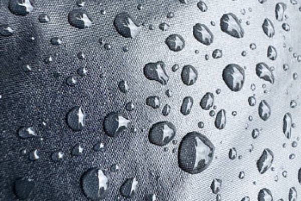 Close-up of water droplets on technical fabric, demonstrating Simmerui waterproof surface treatment
